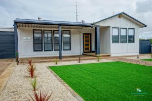 a house with a green lawn in front of it at Breakaway Moonta Bay in Port Moonta