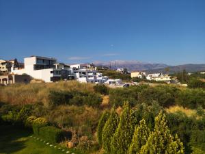 a group of buildings on a hill with trees at Ostria Apartments Kalives in Kalyves