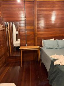 a small room with two beds and a mirror at AREIA BRANCA Chalés in Santo Amaro +17 photos