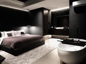 a black bedroom with a bed and a bath tub at The Ruler Bali in Penginyahan +102 photos