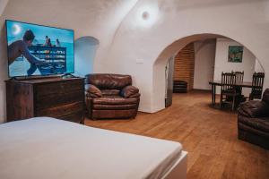 a room with a bed and a tv and a chair at genius loci apartments in Levoča +24 photos