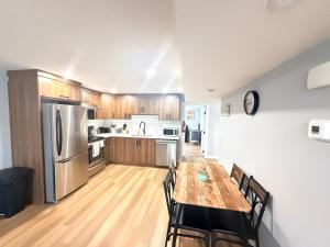 a large kitchen with a wooden table and chairs at 2 bedroom Cozy Secondary-Basement suite in Calgary +9 photos