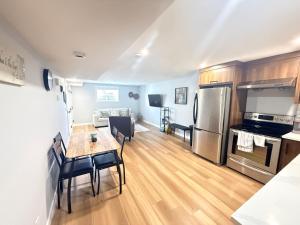 a kitchen and living room with a table and a refrigerator at 2 bedroom Cozy Secondary-Basement suite in Calgary