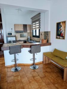a kitchen with a counter and two bar stools at Ostria Apartments Kalives in Kalyves