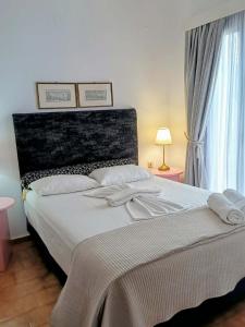 a bedroom with a large white bed and a window at Ostria Apartments Kalives in Kalyves