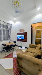a living room with a couch and a table at Merota Apartment in Dar es Salaam +13 photos
