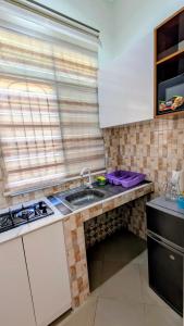 a small kitchen with a sink and a stove at Merota Apartment in Dar es Salaam