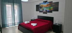 a bedroom with a red bed with a red blanket at Brezza di Mare in Finale