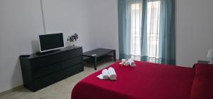 a living room with a red bed and a tv at Brezza di Mare in Finale