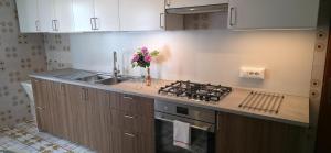 a kitchen with a stove and a vase of flowers at Brezza di Mare in Finale