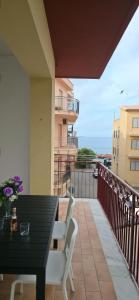 a balcony with a black table and white chairs at Brezza di Mare in Finale