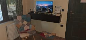 a living room with a tv and a chair at ABC Studios B in Lamía