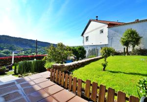 a yard with a fence and a white house at GALIHOST - A Casa do Olivo in Meis