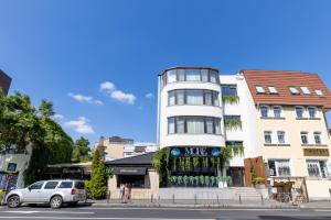a white building with a sign on it on a street at Studio Aparthotel Floreasca 77 in Bucharest