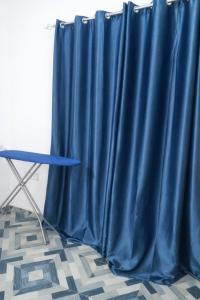 a blue curtain in a room with a table at Cj apartment kasoa in Kasoa
