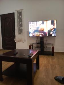 a living room with a coffee table and a flat screen tv at Cj apartment kasoa in Kasoa