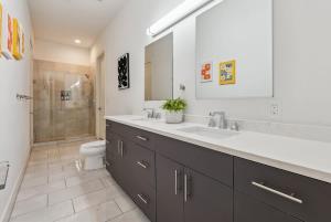 a bathroom with a sink and a toilet and a mirror at Penthouse Luxe Views No 604 in Dallas