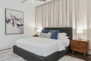 a bedroom with a large bed with blue pillows at Penthouse Luxe Views No 604 in Dallas