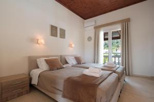 a bedroom with two beds and a window at Katsaros Studios & Apartments in Sidari
