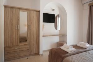 a bedroom with a bed with two towels on it at Katsaros Studios & Apartments in Sidari