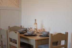 a dining room table with a bottle of wine at Katsaros Studios & Apartments in Sidari