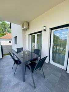 a dining room table and chairs on a patio at Green Nest Apartment in Sárvár