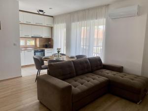 a living room with a couch and a table at Green Nest Apartment in Sárvár