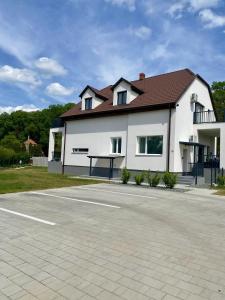 a white house with a table in a parking lot at Green Nest Apartment in Sárvár