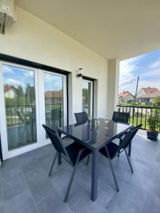 a dining room with a black table and chairs at Green Nest Apartment in Sárvár +6 photos