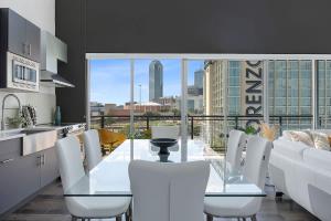 a kitchen with a glass table and white chairs at Penthouse Dallas no 603 in Dallas
