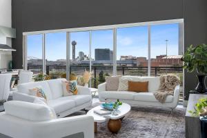 a living room with white furniture and large windows at Penthouse Dallas no 603 in Dallas