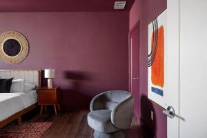 a bedroom with a purple wall with a chair and a bed at Penthouse Dallas no 603 in Dallas +26 photos