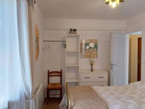a bedroom with a bed and a chair and a table at Palmiers 1 in Barbotan-les-Thermes