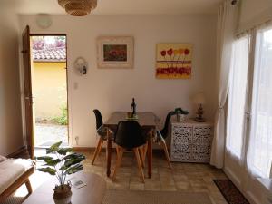 a living room with a table and chairs and a window at Palmiers 1 in Barbotan-les-Thermes