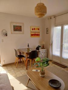 a living room with a table and chairs at Palmiers 1 in Barbotan-les-Thermes +17 photos
