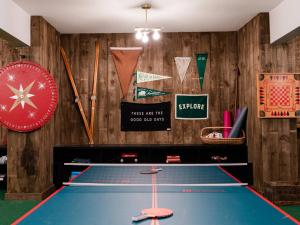 a ping pong table in a room with baseball bats at Hideaway Inn Mt Sunapee in Newbury
