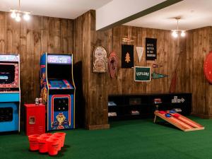 a room with two arcade machines and a table andools at Hideaway Inn Mt Sunapee in Newbury