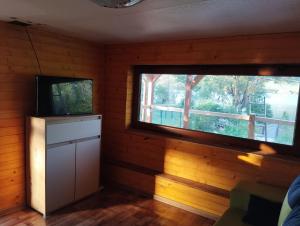 a room with a tv and a window at Domček pri vode Pohoda in Teplý Vrch
