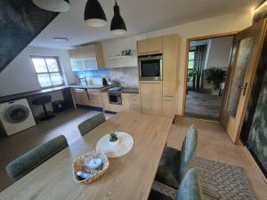 a kitchen and dining room with a wooden table and chairs at FeWo im Forsthaus in Marktredwitz