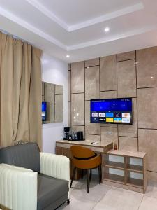a living room with a couch and a table and a tv at Purple Lavender Hotel Lekki in Lekki