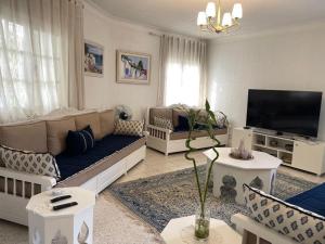 a living room with a couch and a tv at Villa Jasmin in Hammamet
