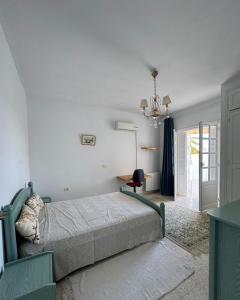 a bedroom with a bed and a desk and a chandelier at Villa Jasmin in Hammamet