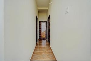 a hallway with white walls and wooden floors at Hotel O RJ HOTEL INN in Pānchgaon