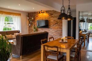 a dining room and living room with a wooden table at apartament BB in Podgórzyn