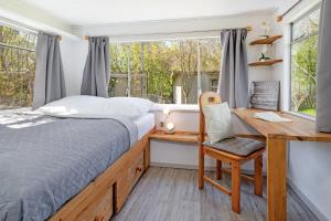 a bedroom with a bed and a desk and a window at Alte Dorfstraße 29 REETungsring in Behrensdorf