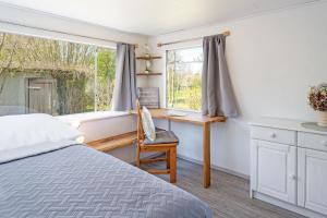 a bedroom with a bed and a desk and a window at Alte Dorfstraße 29 REETungsring in Behrensdorf