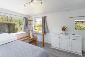 a bedroom with a bed and a desk and a window at Alte Dorfstraße 29 REETungsring in Behrensdorf +15 photos