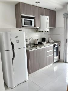 a kitchen with a white refrigerator and a microwave at HOMEFULL Apartamentos in Salta +41 photos
