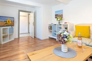a living room with a vase of flowers on a table at Alte Dorfstraße 29 REETungsboot in Behrensdorf