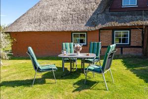 a table and chairs in front of a house at Alte Dorfstraße 29 REETungsboot in Behrensdorf +20 photos